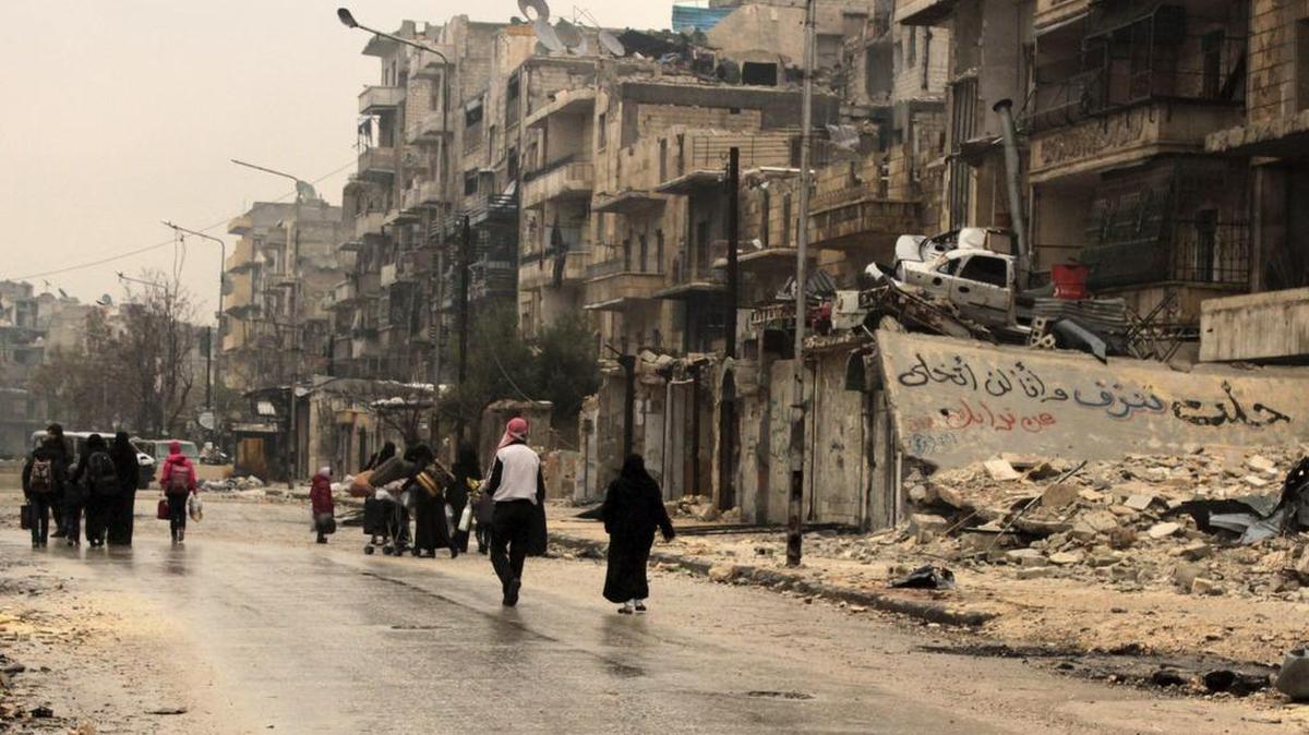 Varias personas caminan por las calles del barrio de al-Mashad en la zona controlada por los rebeldes en Alepo (Siria) el 14 de diciembre de 2016.