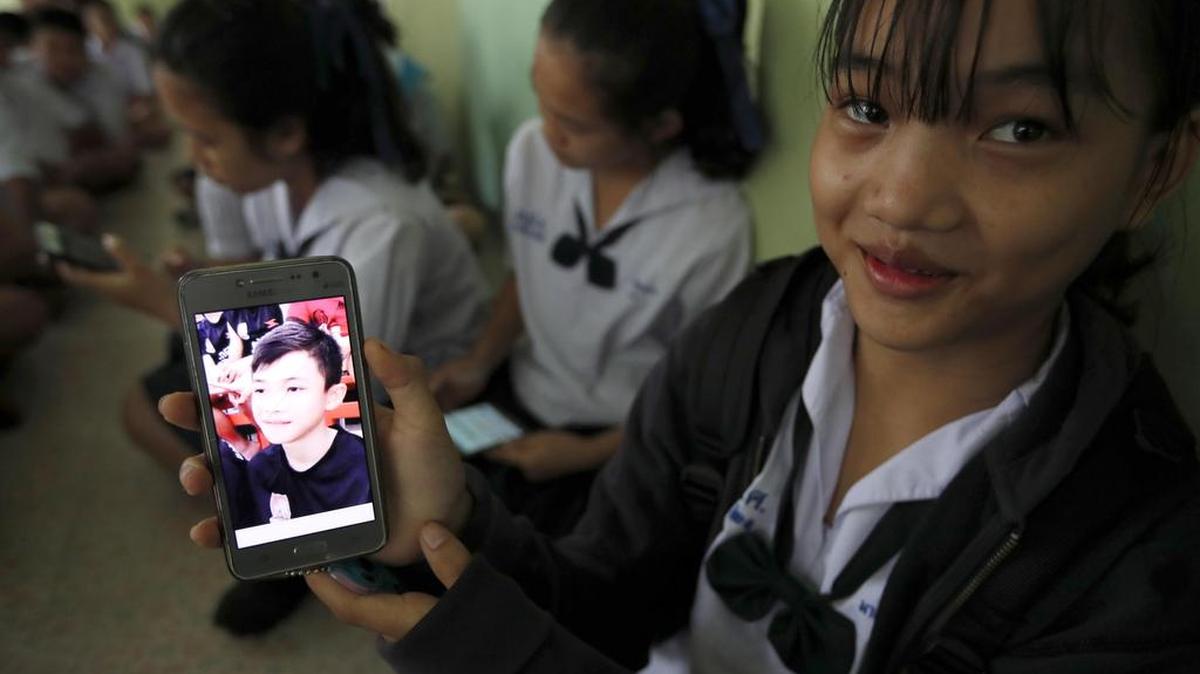  Una estudiante tailandesa muestra una fotografía de su compañero de clase, Duangpetch Promthep, quien se encontraba atrapado en una cueva y fue recientemente rescatado, en el distrito de Mae Sai, Chiang Rai, (Tailandia) el miércoles 11 de julio de 2018. 