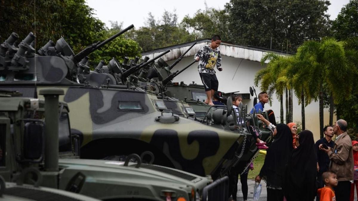 Un niño tailandés sube a un tanque militar en una base del ejército durante las celebraciones del Día del Niño.