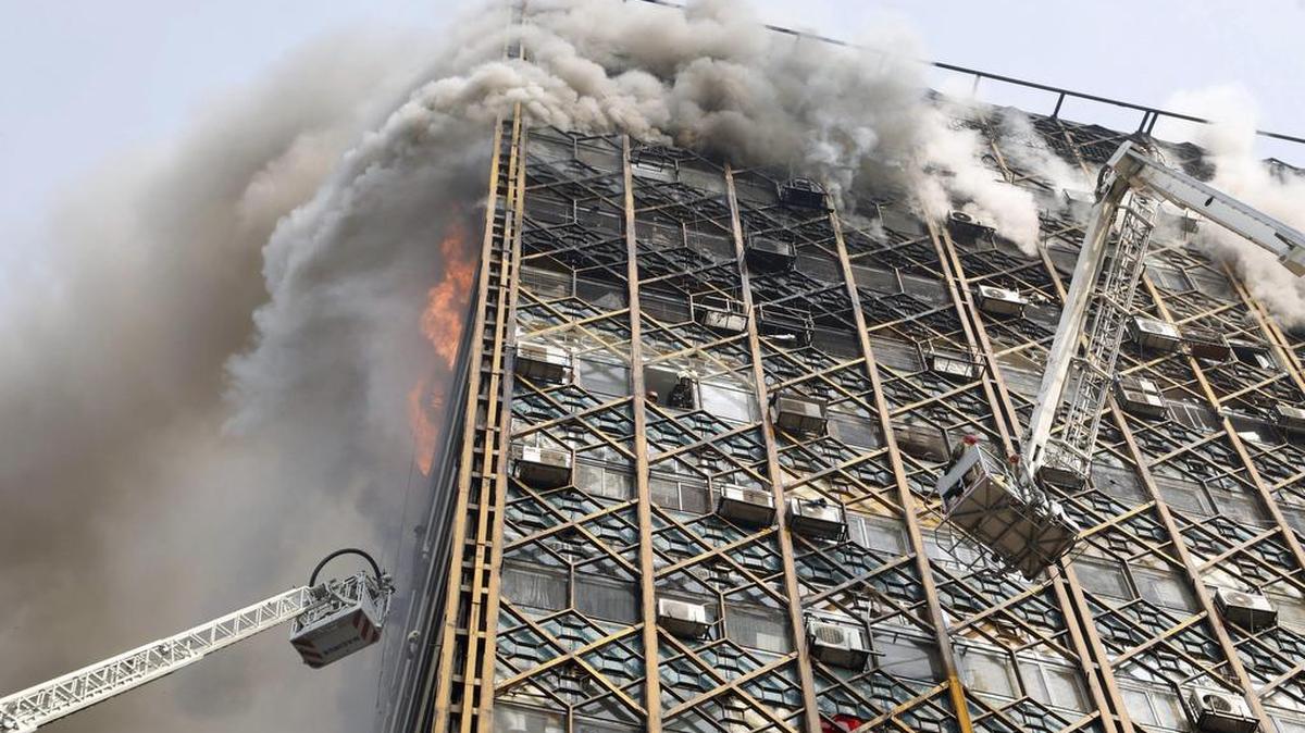 Bomberos iraníes luchan para sofocar las llamas en el edificio Plasco antes de su derrumbe como consecuencia de un grave incendio, en Teherán (Irán), el 19 de enero de 2017.