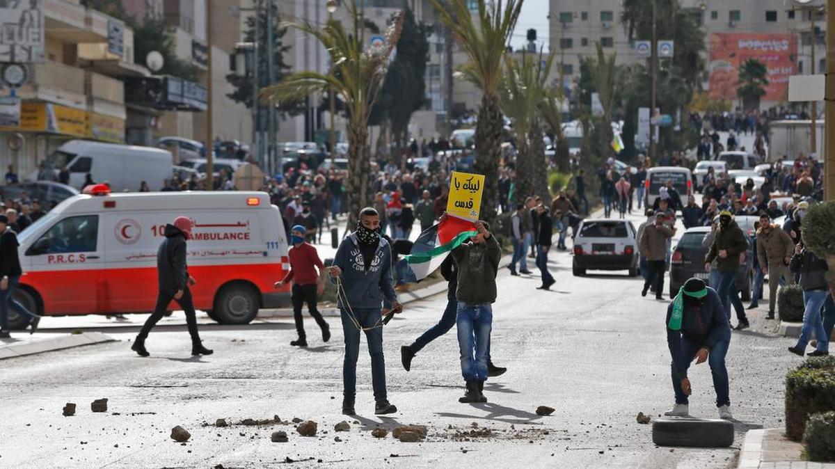 Manifestantes palestinos chocan con las fuerzas israelíes cerca de un puesto de control israelí en la ciudad cisjordana de Ramallah el 7 de diciembre de 2017.