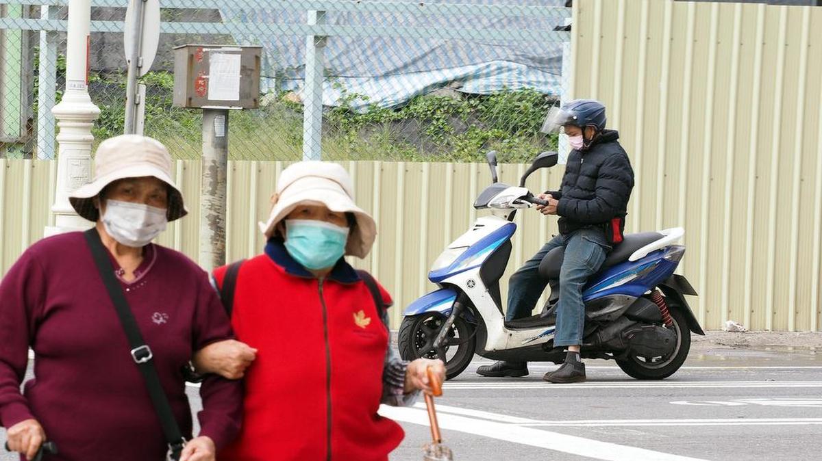 Dos ancianas con mascarillas conversan en Kaohsiung, en el sur de Taiwán, el 1ero de diciembre de 2017.