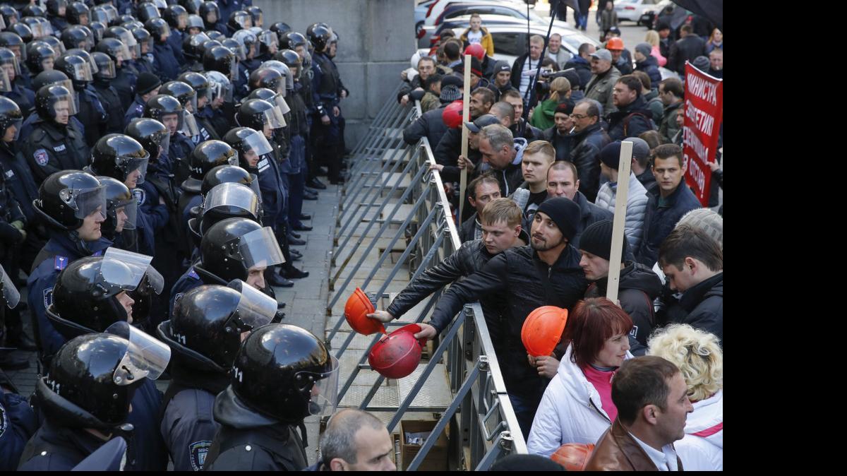 
Mineros ucranianos hacen ruido con sus cascos frente a los antidisturbios mientras protestan delante de la sede de la Administración Presidencial en Kiev, Ucrania, el miércoles.


