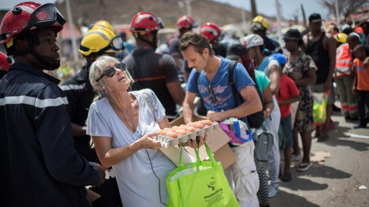 Residentes de San Martín, una de las islas de las Antillas más duramente castigadas por el huracán Irma, hacen fila para recibir alimentos que reparten las autoridades.