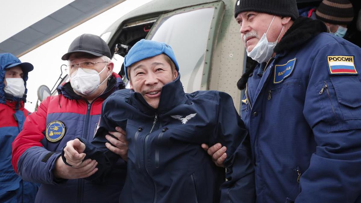 El emprendedor japonés Yusaku Maezawa, participante de un vuelo espacial, recibe ayuda mientras desembarca de un helicóptero cuando llega al aeropuerto después de regresar de la Estación Espacial Internacional en la cápsula espacial Soyuz MS-20, en Zhezkazgan, Kazajstán, el lunes 20 de diciembre de 2021. (Shamil Zhumatov/Pool Photo via AP)