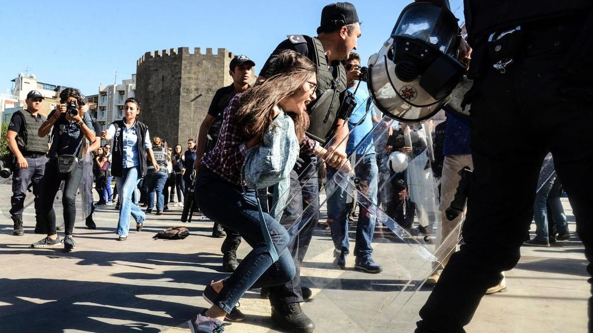 Un policía turco detienen a una estudiante durante una protesta por la suspensión de profesores vinculados al fallido golpe militar.