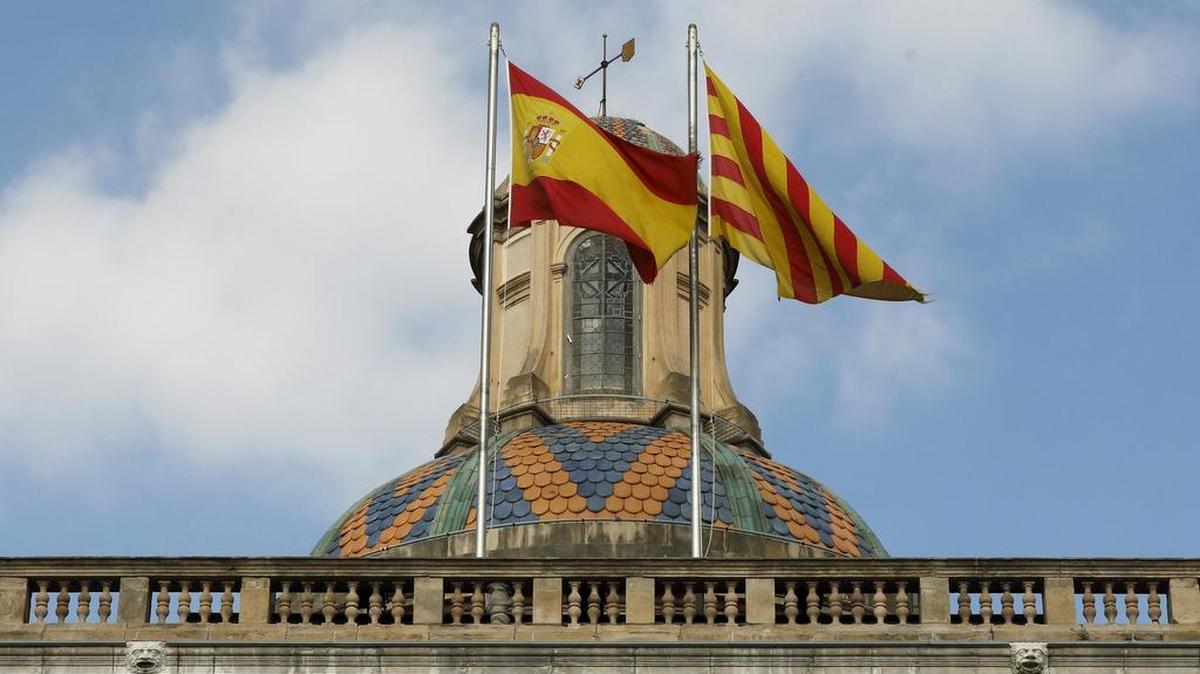 Las banderas española y catalana ondean ondean en la fachada del edificio de la Generalitat de Catalunya en la plaza de Sant Jaume tras la declaración unilateral de independencia ayer en el parlamento autonómico.