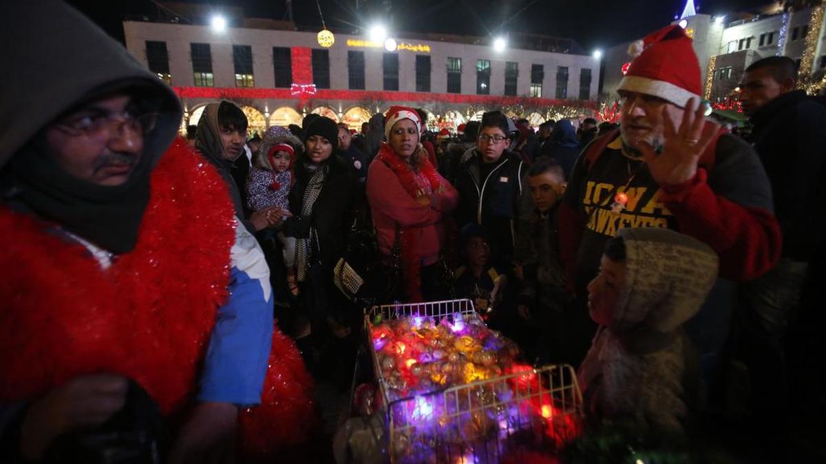 Personas se unen a las celebraciones de Nochebuena el 24 de diciembre de 2016 en la Plaza de Manger junto a la Iglesia de la Natividad, venerado como el lugar del nacimiento de Jesucristo, en la ciudad bíblica de Cisjordania de Belén.