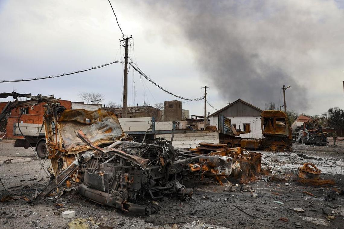 Burned vehicles are seen at the destroyed part of the Illich Iron & Steel Works Metallurgical Plant, as smoke rises from the Metallurgical Combine Azovstal during heavy fighting, in an area controlled by Russian-backed separatist forces in Mariupol, Ukraine, Monday, April 18, 2022. Mariupol, a strategic port on the Sea of Azov, has been besieged by Russian troops and forces from self-proclaimed separatist areas in eastern Ukraine for more than six weeks.