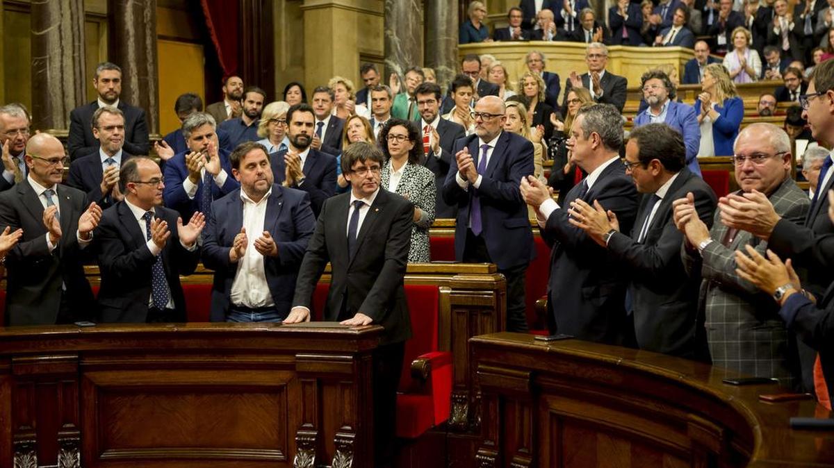 El presidente de la Generalitat, Carles Puigdemont (c) tras su discurso ante el pleno del Parlament donde esta tarde comparece para explicar la situación política y en la que podría anunciar una eventual declaración de independencia.