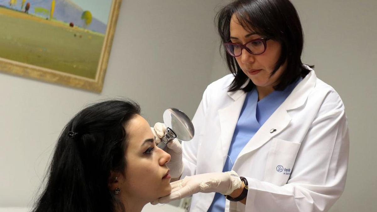 La dermatóloga Monika Fida (R) examina a una mujer en su clínica el 10 de enero de 2017.