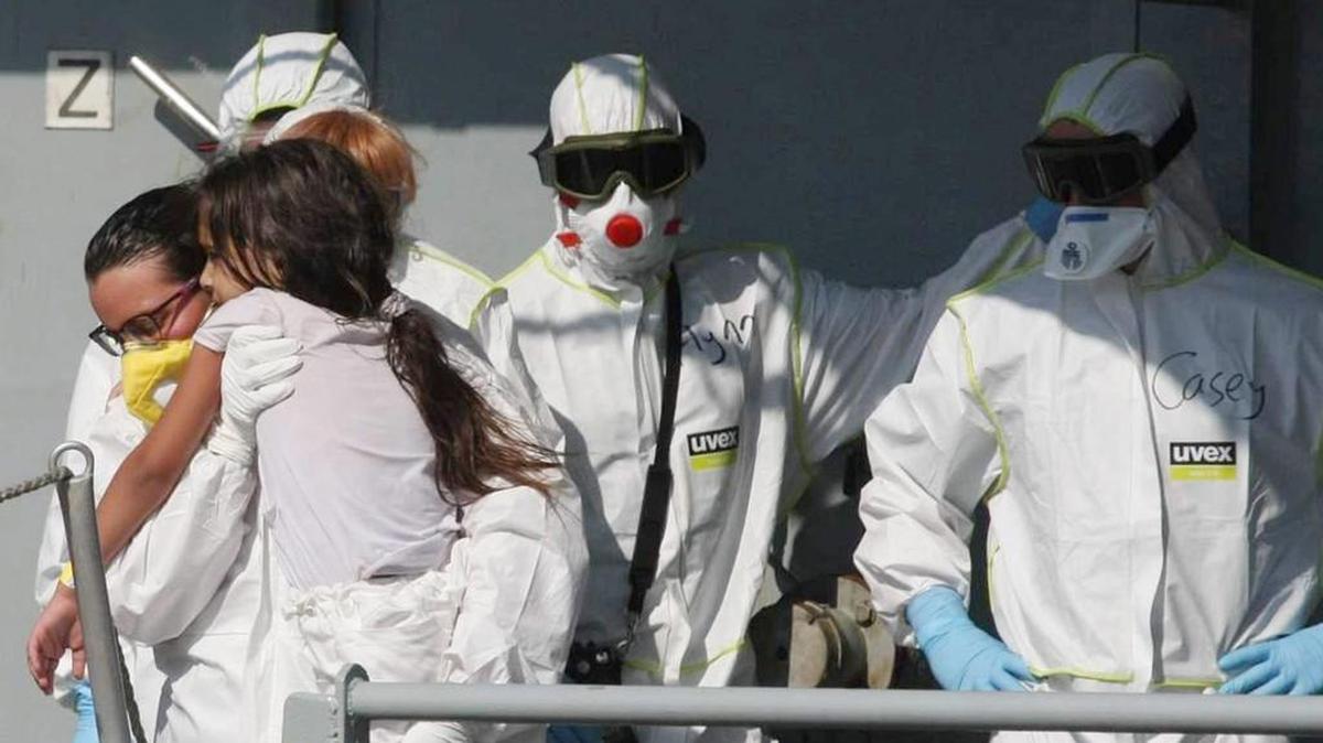 
Miembros de la tripulación en trajes blancos junto con algunos de los 373 rescatados del naufragio en las costas libias a bordo del barco de la Marina irlandesa “Lé Niamh” a su llegada al puerto de Palermo, Italia, este jueves.
