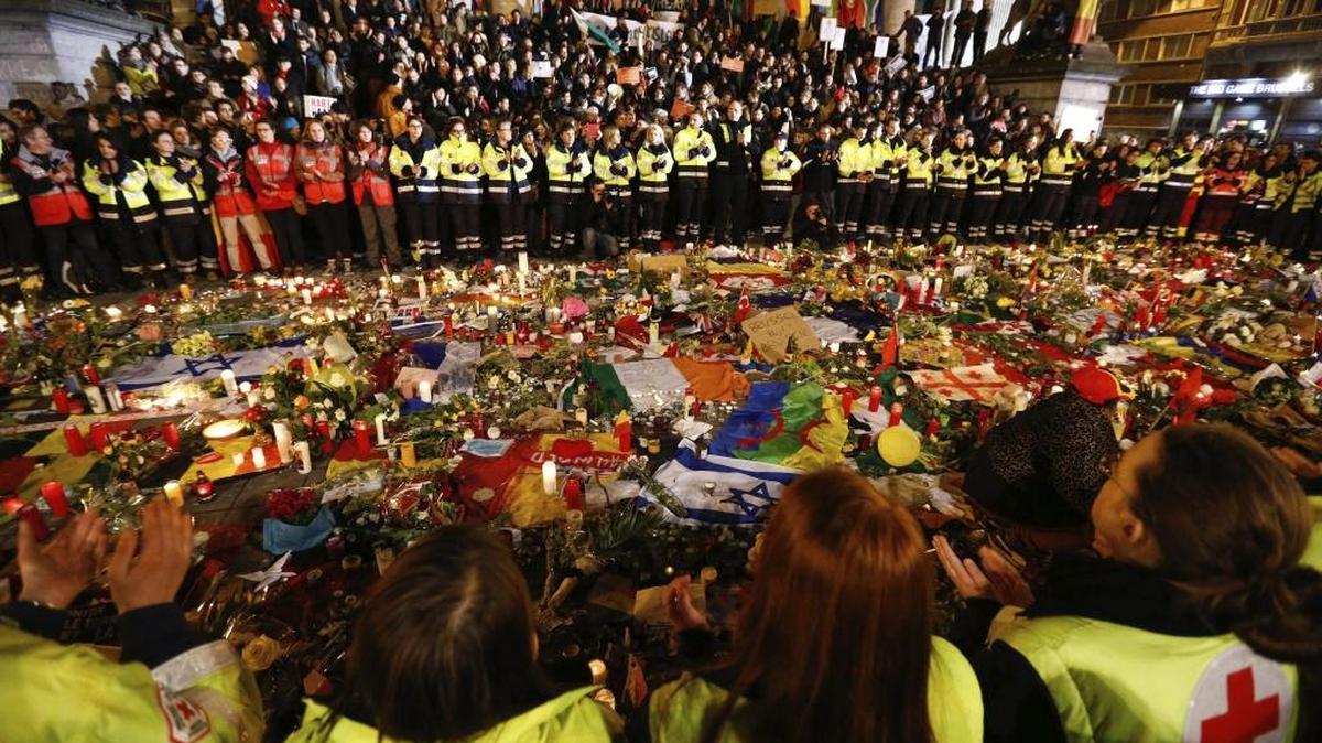 Trabajadores de los servicios de emergencia guardan un minuto de silencio en la Plaza de la Bolsa en Bruselas (Bélgica) hoy, 25 de marzo de 2016 tras los atentados del pasado martes en el que murieron 31 personas y hubo 300 heridos de cerca de una cuarentena de nacionalidades.