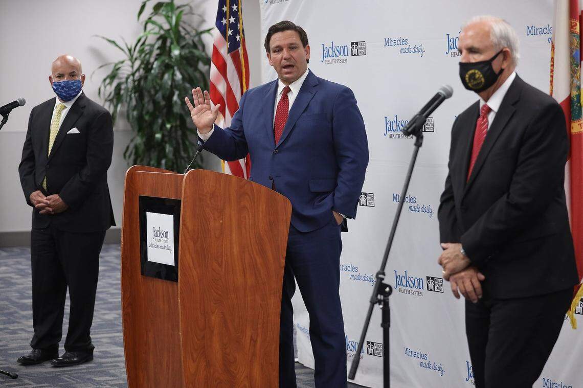 Florida Gov. Ron DeSantis (center), seen here at a press conference on July 13, 2020 in Miami, has extended the statewide moratorium on evictions and foreclosures until Sept. 1.