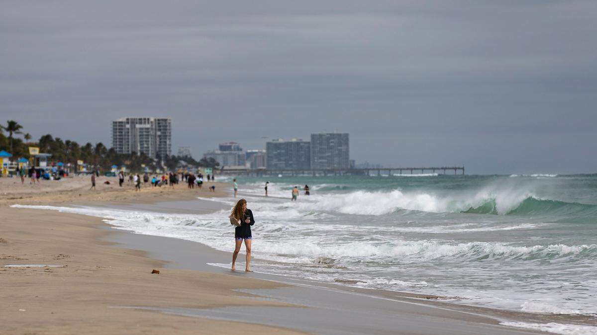 Fuertes olas rompen en la playa mientras la gente visita el Hollywood Beach Broadwalk el lunes 19 de febrero de 2024 en Hollywood, Florida.