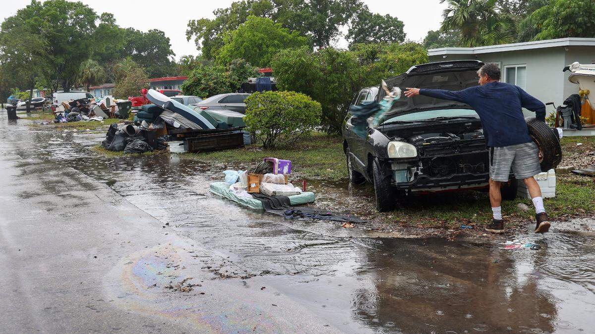 Paul Guerrero, residente del condado Broward, continúa el proceso de limpieza en su casa mientras los artículos desechados dañados por el agua se amontonan en la calle del vecindario. El lunes 17 de abril de 2023, menos de una semana después de que las lluvias incesantes inundaran las calles del vecindario de Edgewood en Fort Lauderdale, los residentes continuaron limpiando sus casas empapadas. Muchos trabajaron duro con la esperanza de poder salvar sus hogares y volver a vivir allí.