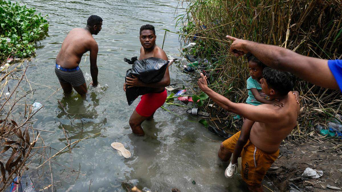 Migrantes cruzan el río Bravo hacia el lado estadounidense desde Matamoros, México, el jueves 11 de mayo de 2023.