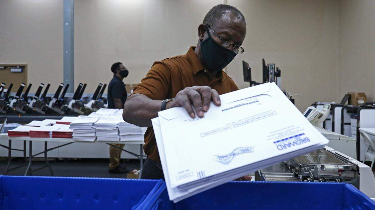 ARCHIVE: Hubert Patrick, a Broward County Elections Department worker, prepares mail-in ballots to be mailed to voters on July 9, 2020 at the Broward Voter Equipment Center in Lauderhill.