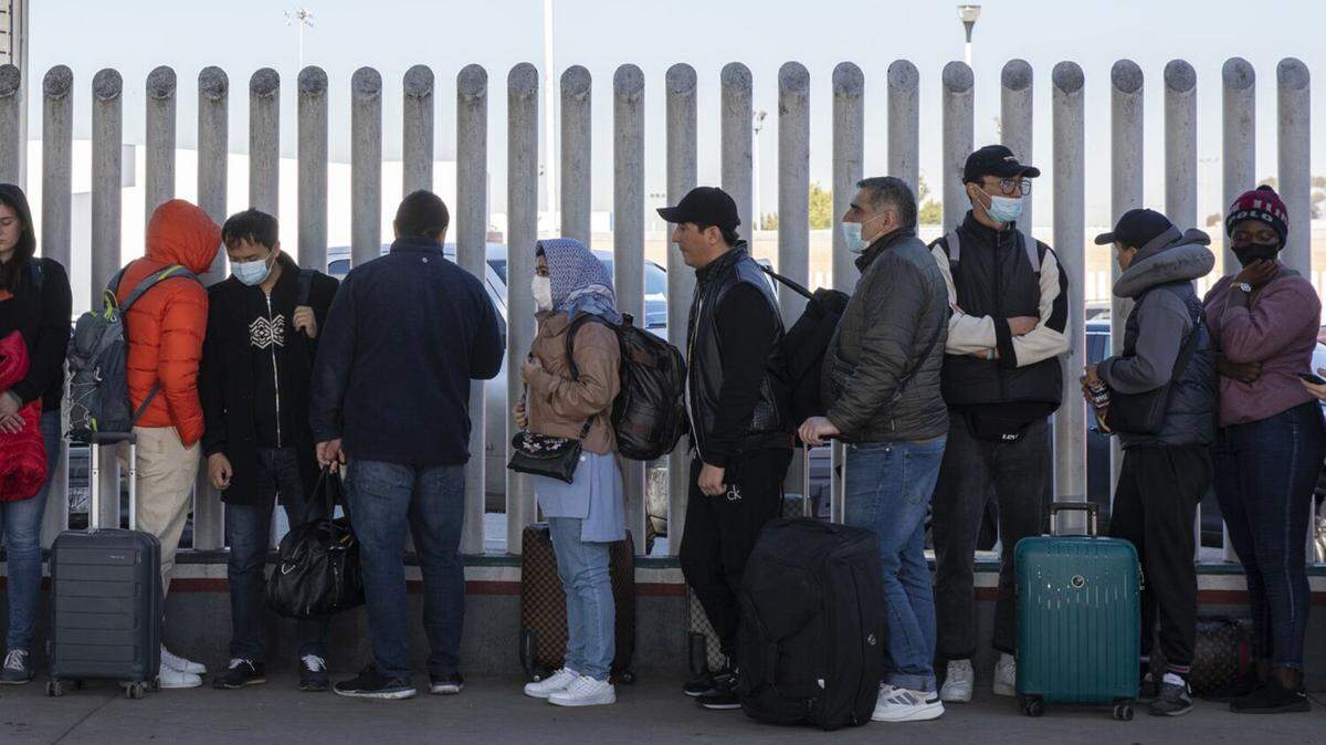 Cerca de 80 inmigrantes de varios países que buscan asilo en Estados Unidos esperan en un puerto de entrada para ser procesados, el miércoles 21 de diciembre de 2022, en Tijuana, Baja California, México. (Ana Ramirez/The San Diego Union-Tribune/TNS)