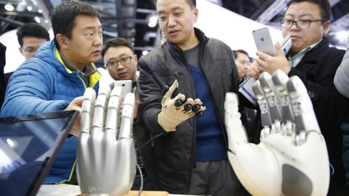 Un hombre prueba a controlar una mano robótica en la Conferencia Mundial de Robots en Pekín (China) el 23 de noviembre de 2015. La conferencia se celebra del 23 al 25 de noviembre e incluye una exposición, un foro y una competición de robótica para adolescentes.