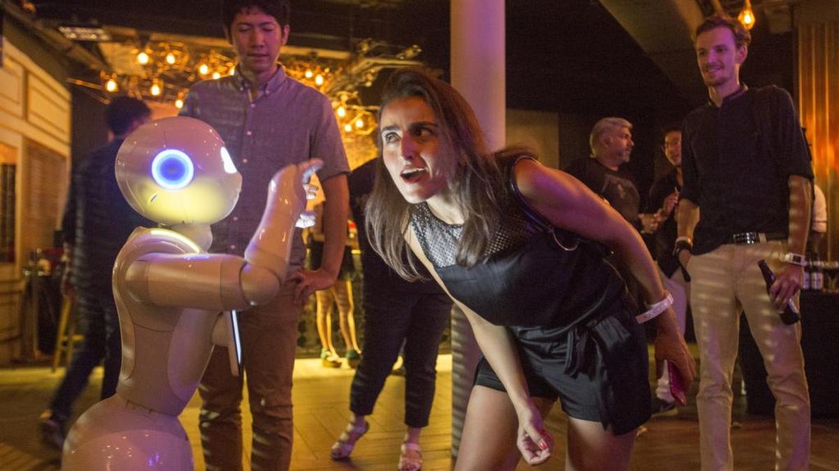 
Los visitantes de una feria tecnológica en singapur interactúan con el robot personal Pepper.
