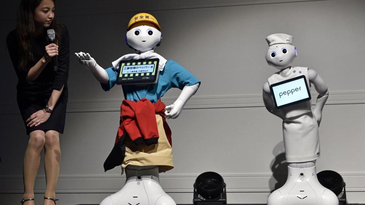 Un robot Pepper presenta un atuendo de obrero de la construcción (izq) durante el concurso de moda Tokyo Pepper Collection 2017 en Tokio (Japón) hoy, 9 de febrero de 2017.