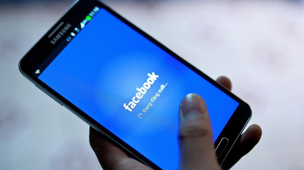 Imagen de archivo que muestra a una persona mientras inicia la red social Facebook en un teléfono móvil en Hanói, Vietnam, el 28 de noviembre de 2013.