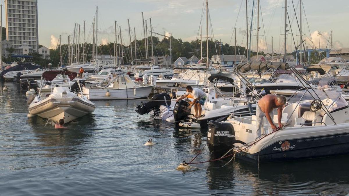 Residentes de la isla Guadalupe aseguran sus barcos el 4 de septiembre de 2017 en el puerto de Pointe-à-Pitre como parte de los preparativos ante la llegada del huracán Irma.