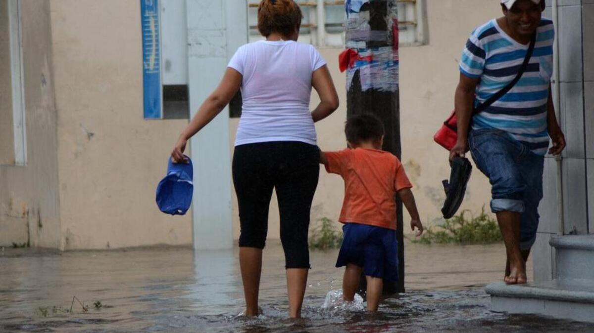 Habitantes del Puerto de Veracruz (México) caminan por las calles inundadas debido a la Tormenta Torpical Earl el viernes 5 de agosto de 2016.