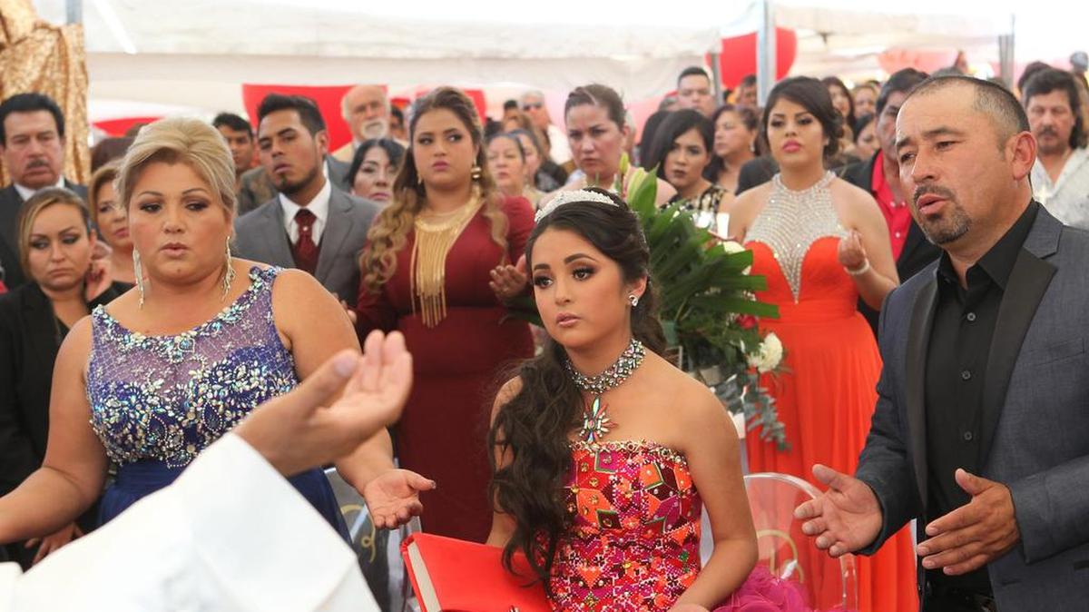 La joven mexicana Rubí (c) junto a sus padres en una misa en el marco de su fiesta de 15 años el lunes 26 de diciembre de 2016, en La Joya (México).