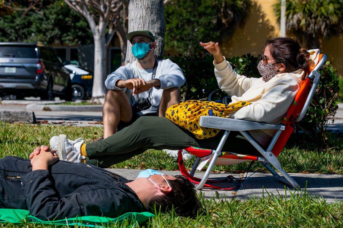 Los amigos Julio Cesar, de 39 años (frente) y Daniel Rivero, de 34 (izq.) esperan para ser vacunados, mientras Lujain Alhajji, de 34 (der.), quien ya fue inoculado, los acompaña el domingo 7 de marzo de 2021, en el Centro de Vacunación FEMA en la ciudad de Florida City.
