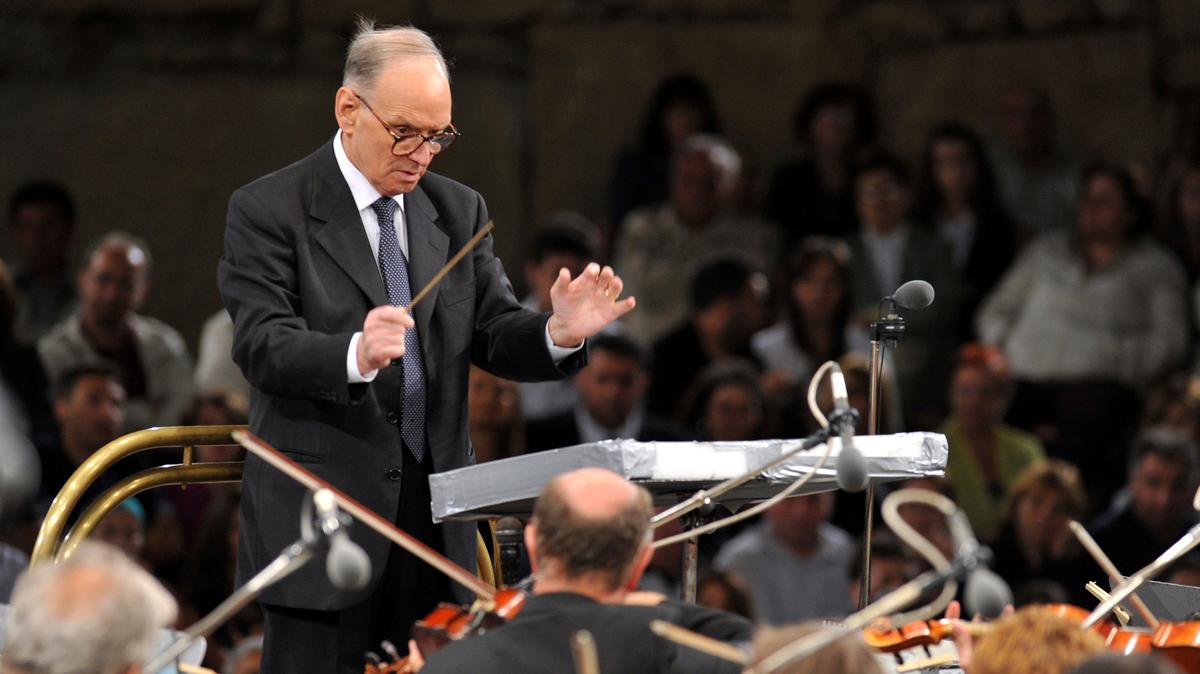 En esta foto del 12 de julio de 2009, el compositor italiano Ennio Morricone dirige a la Orquesta Sinfónica de Budapest - Gyor, tocando algunas de sus piezas más emblemáticas para el cine junto al Coro de la Ópera de Macedonia, la noche inaugural del 49no Festival de Verano de Ohrid, en el sur de Macedonia. Morricone, creador de las bandas sonoras del emblemático spaghetti western “El bueno, el malo y el feo” y clásicos de mafiosos de Hollywood como “Los intocables”, murió el lunes 6 de julio de 2020 en un hospital de Roma. Tenía 91 años. (AP Foto/Boris Grdanoski, Archivo)