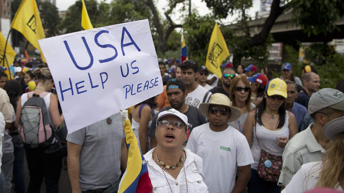 Una mujer sostiene una pancarta en donde pide ayuda a Estados Unidos con la crisis política en Venezuela, durante una protesta contra el gobernante Nicolás Maduro el 26 de octubre de 2016 en Caracas.