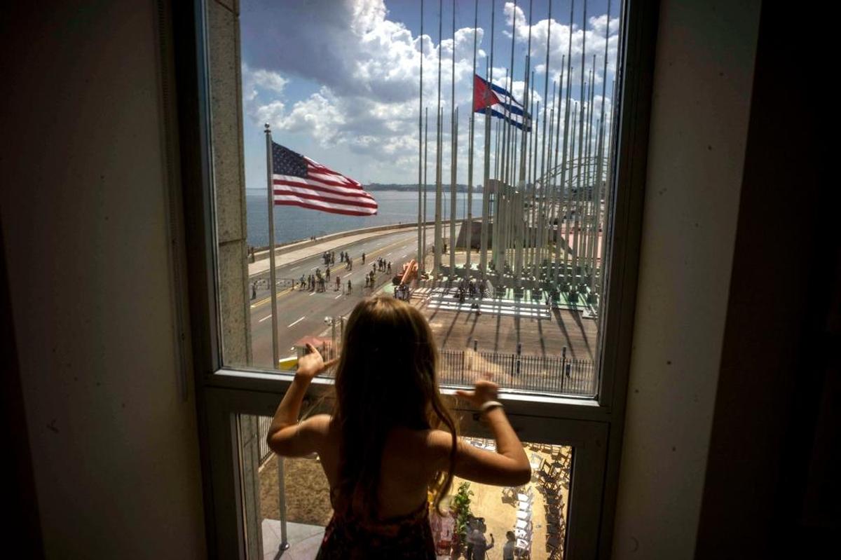 Una niña mira por la ventana la ceremonia del izamiento de las banderas desde la embajada de Estados Unidos en La Habana, el 14 de agosto de 2015.