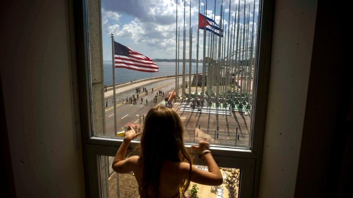 Una niña mira por la ventana la ceremonia del izamiento de las banderas desde la embajada de Estados Unidos en La Habana, el 14 de agosto de 2015.