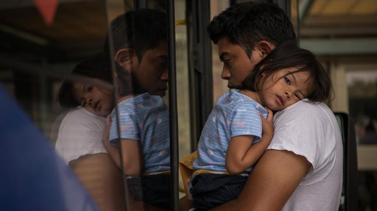 Un inmigrante hondureño recién liberado de un centro de detención federal aborda un autobús con su hija de 2 años, el martes 11 de junio de 2019, en McAllen, Texas.