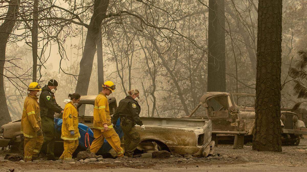Bomberos y rescatistas trasladan el cadáver de una de las víctimas de los incendios forestales el pasado miércoles, en Paradise, California.
