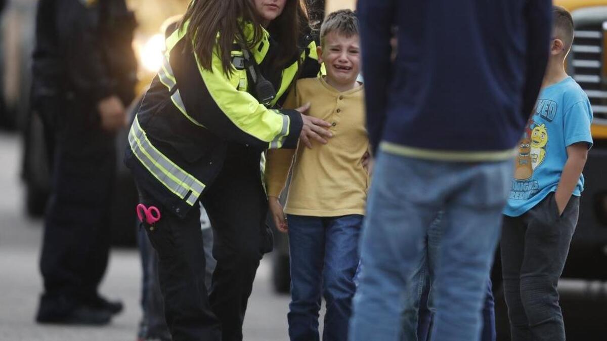 Agentes policiales trasladan a niños de una escuela a otro lugar después que ocurrió un tiroteo el 7 de mayo en una secundario en Highlands Ranch, un suburbio de Denver, Colorado.