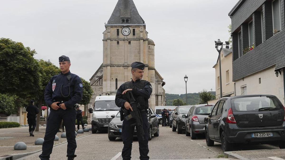 Agentes de policía vigilan el acceso a la iglesia donde terroristas del Estado Islámico asesinaron el martes pasado a un sacerdote católico.