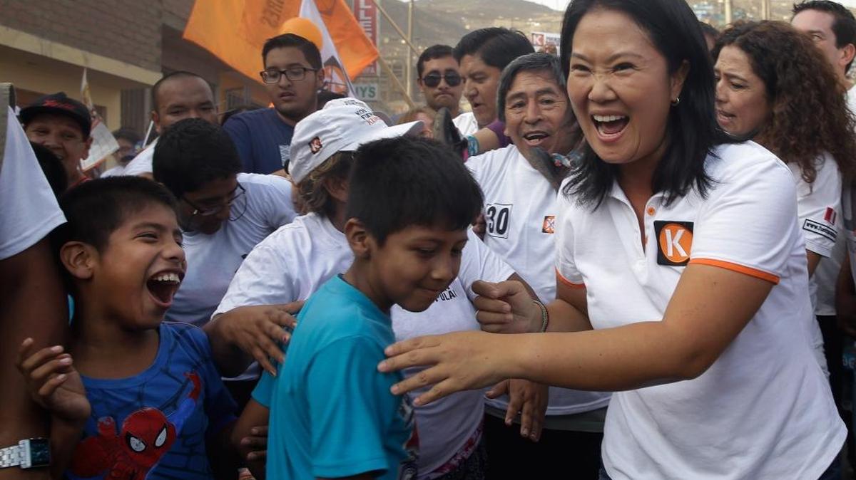 La candidata presidencial peruana Keiko Fujimori (der.), del partido Fuerza Popular, saluda a sus simpatizantes en San Juan de Lurigancho, un barrio pobre en las afueras de Lima, el pasado 22 de marzo.