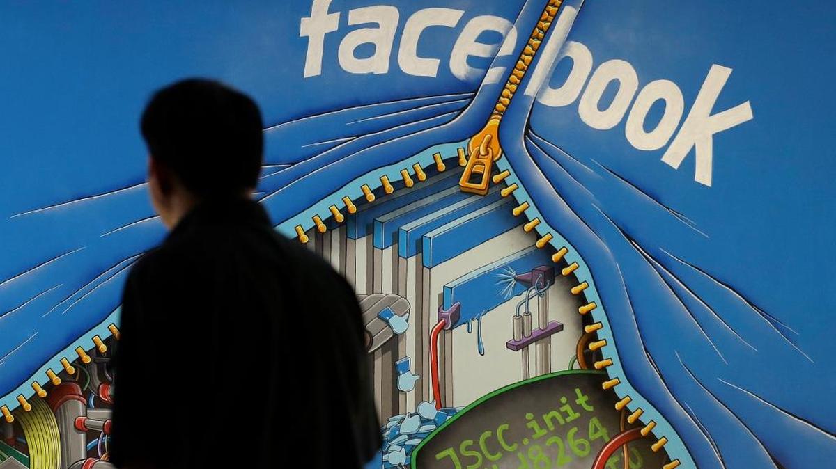Un hombre pasa frente a un mural en la oficina de Facebook en Menlo Park, California.