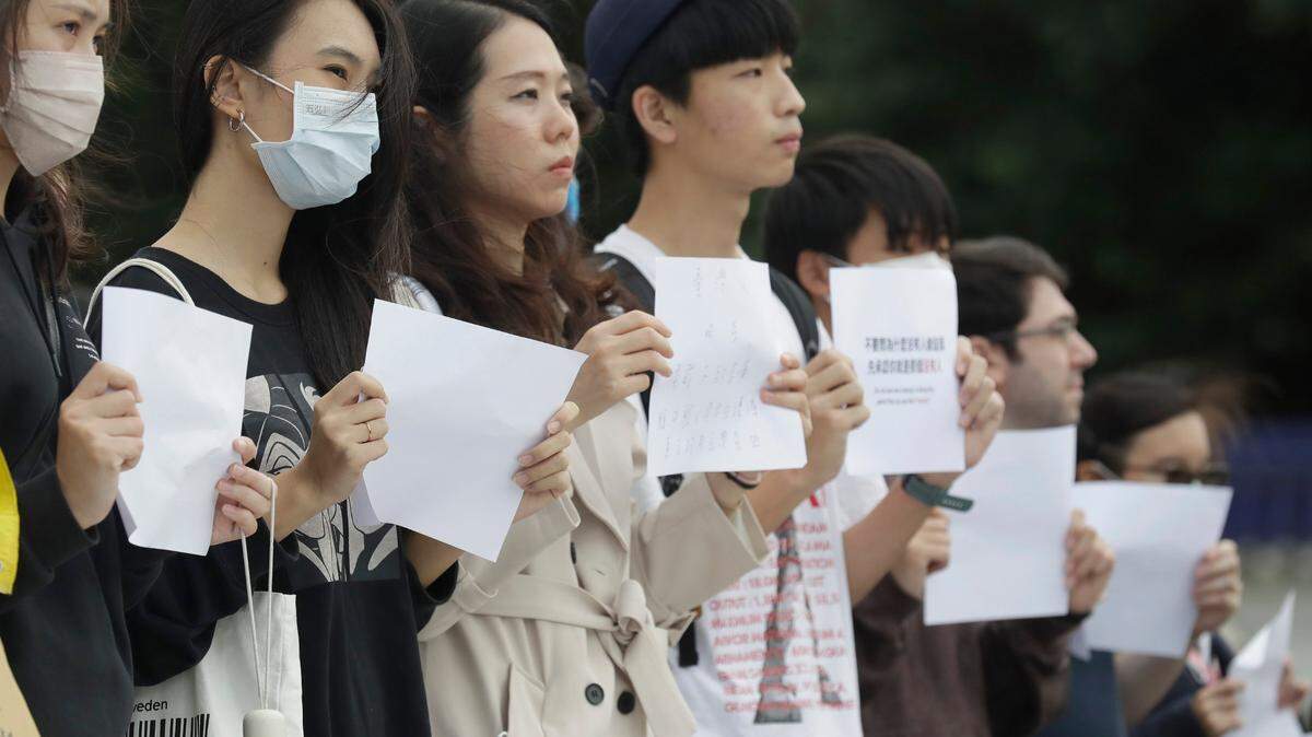 Una decena de personas sostiene un papel de formato A4 en la Plaza de la Libertad en Taipei, Taiwán, el domingo 4 de diciembre de 2022. Más de 50 manifestantes portaron libros blancos en apoyo al pueblo chino bajo las duras políticas de cero COVID que les impiden tener una vida normal en China. (Foto AP/Chiang Ying-ying)