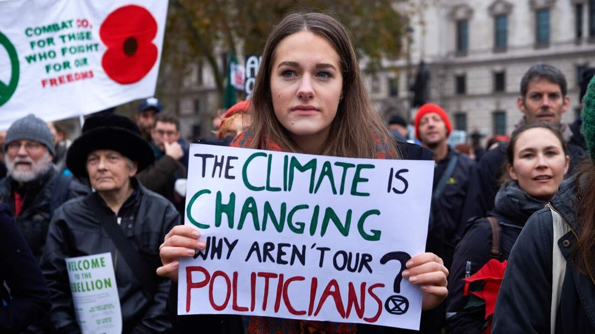 “El clima está cambiando, ¿por qué no lo hacen nuestros políticos”, dice la pancarta de esta mujer durante una protesta para exigir medidas que reduzcan el impacto del cambio climático, el 24 de noviembre en Londres.