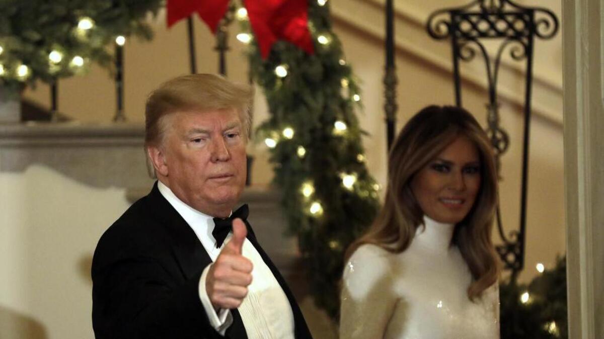 El presidente Donald Trump y la primera dama, Melania Trump, saludan a los invitados de una gala especial el 15 de diciembre en la Casa Blanca.