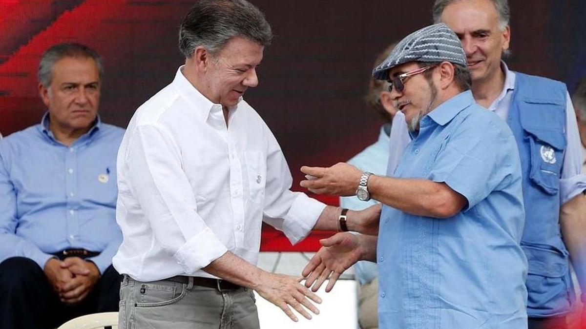 El presidente de Colombia, Juan Manuel Santos, izquierda, saluda al líder de las FARC, Rodrigo Londoño.