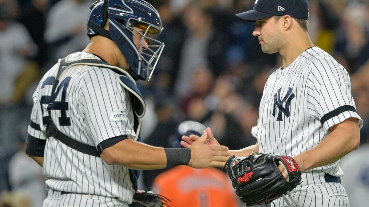 El lanzador Tommy Kahnle (der.), de los Yankees de Nueva York, celebra con el receptor Gary Sánchez la victoria 5-0 de su equipo frente a los Astros de Houston, en el Yankee Stadium, el 18 de octubre.