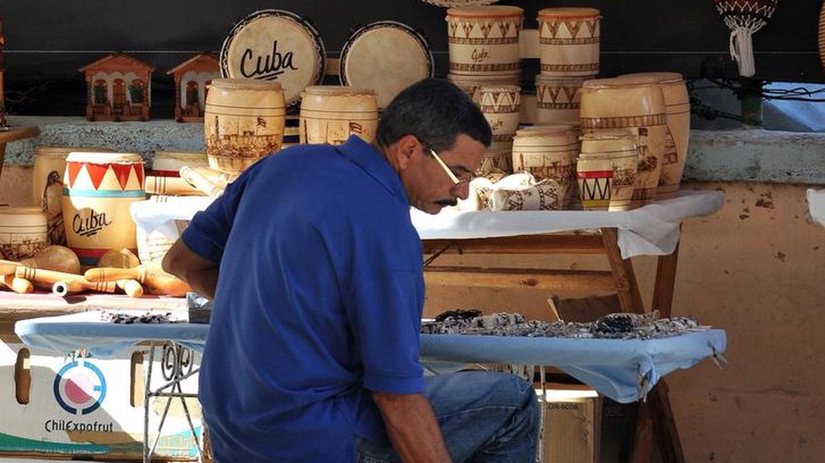 Un hombre atiende un pequeño puesto privado de venta de artesanías, en La Habana.