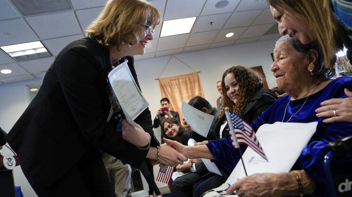 La funcionaria de inmigración Kimberly Zanotti (izq.) presenta el certificado de naturalización a la salvadoreña María Valles Bonilla, de 106 años, durante una ceremonia donde obtuvo la ciudadanía de EEUU, el 6 de noviembre en Fairfax, Virginia.