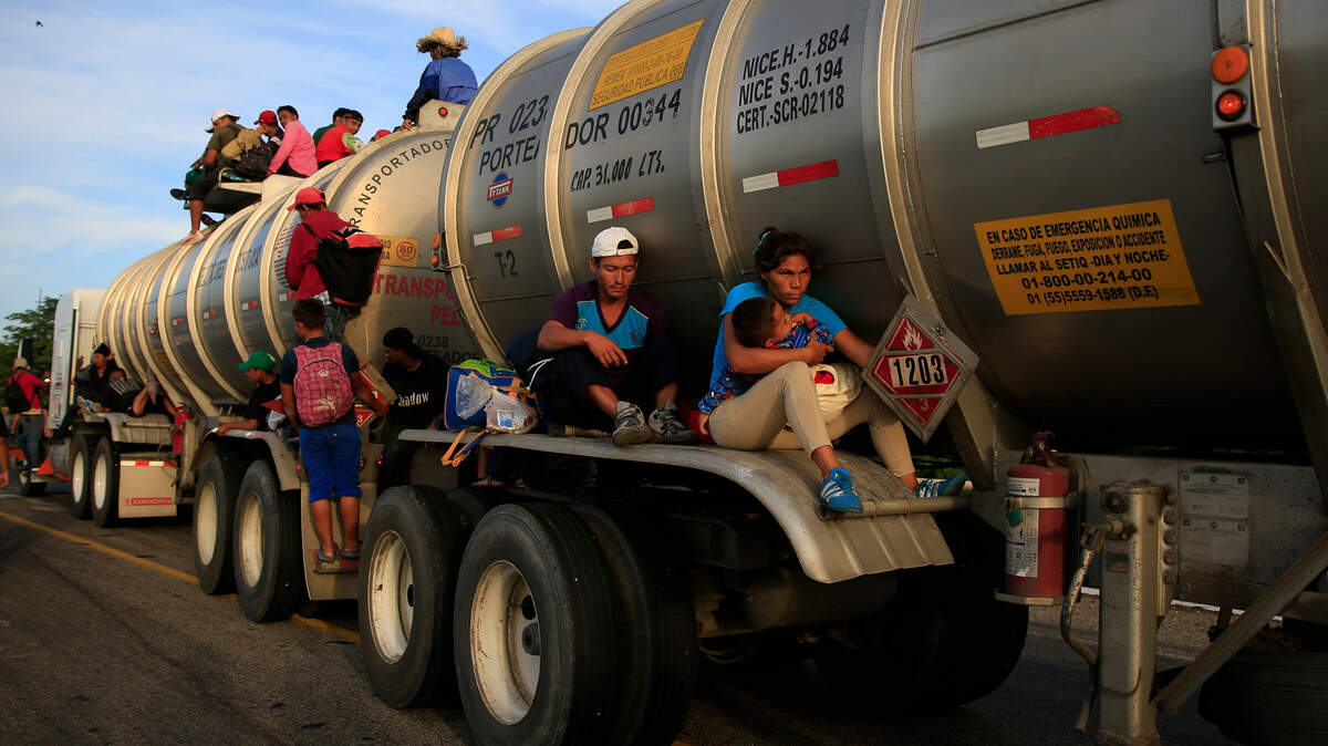 Una mujer con su bebé y otros inmigrantes logran ser transportados en un camión de transporte de gasolina, el martes, en Niltepec, México. Miles de inmigrantes continuaron su lento avance en caravana hacia la frontera con Estados Unidos.