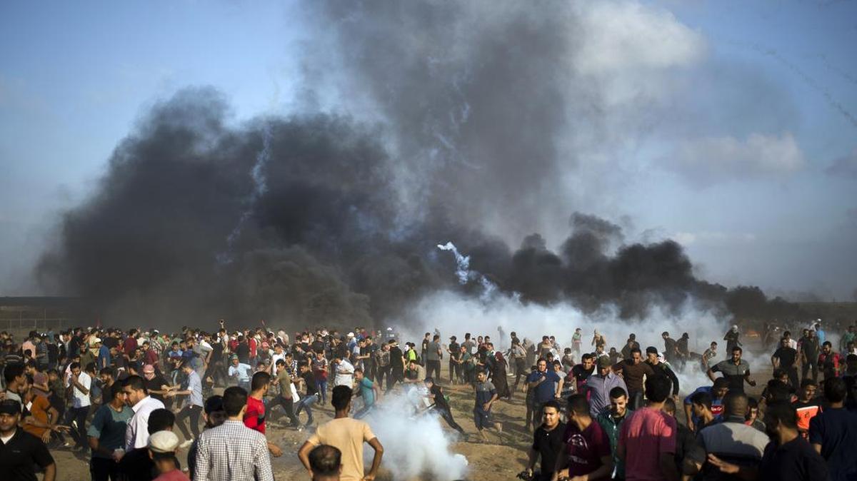 Manifestantes palestinos escapan del gas lacrimógeno disparado por tropas israelíes durante una protesta en el límite de la Franja de Gaza con Israel, el 3 de agosto.